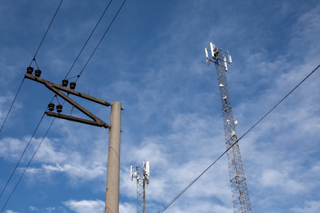 Telecommunication tower in European Union. Dark blue sky with white clouds in the background