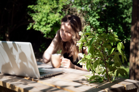 Job with computer outdoors by wooden table at country, work from home. Business and freelancer conceptの写真素材