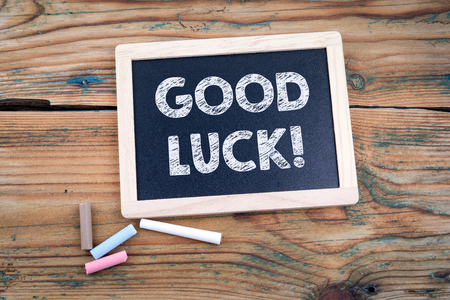 Good luck. blackboard and old wooden table with textureの写真素材