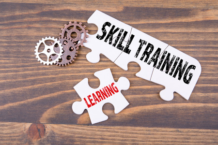 Skill training and learning concept. White puzzle on a wooden tableの写真素材