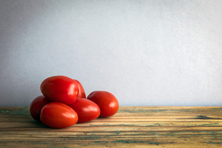 Tomatoes on an old wooden table. Free space for your textの写真素材