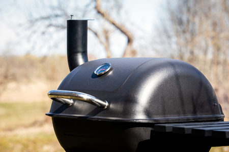 Black big barrel grill in the garden. Spring and summer seasonの写真素材