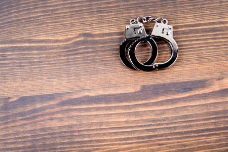 Handcuffs on a dark wood background. Corruption, crime and lawの写真素材