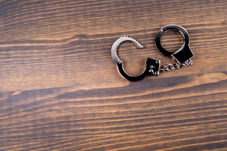 Handcuffs on a dark wood background. Corruption, crime and lawの写真素材