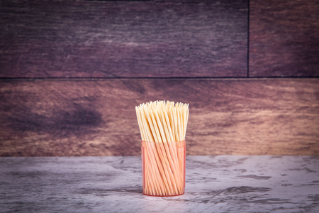 Toothpicks in a box. Marble table and plank backgroundの写真素材