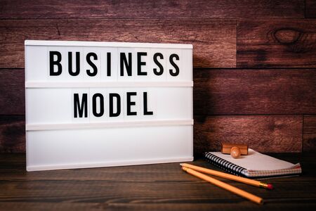 Business model. Text in lightbox. Wooden office tableの写真素材