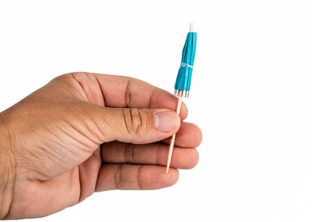 Holding cocktail umbrella in the hand. White backgroundの写真素材