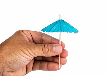 Holding cocktail umbrella in the hand. White backgroundの写真素材