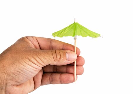 Holding cocktail umbrella in the hand. White backgroundの写真素材