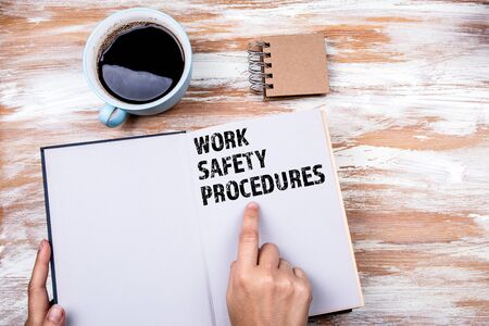 Work Safety and Safety Procedures concept. Hands holding book on office tableの写真素材