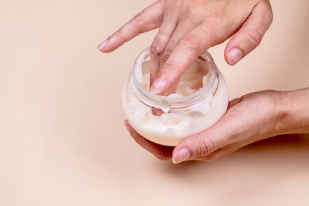 Applying cream on tired, swollen hands, beauty and health concept