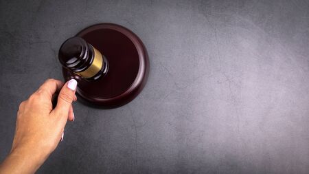 Judge hammer in hand of woman. Free space for text, copy spaceの写真素材