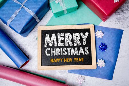 Merry Christmas and Happy New Year greetings. Chalkboard, gifts and decorations.の写真素材