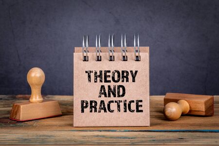 Theory and Practice. Notepad on a dark background.の写真素材