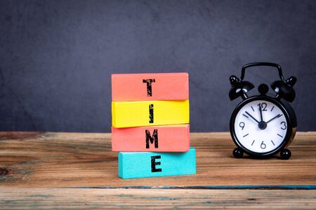 Time concept. Office table and colorful wooden blocks with textの写真素材