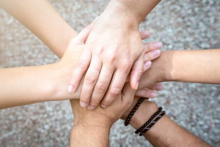 Close up top view of people putting their hands together. Friends with stack of hands, unity and...
