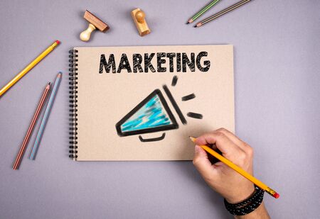 Marketing concept. Megaphone icon. Notepad on gray table