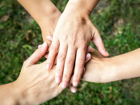 Close up top view of people putting their hands together. City parkの写真素材