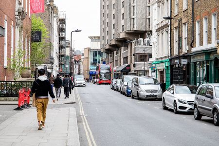 Pedestrians in the street of London, light traffic on driveway. Shops, cafes and companies by the streetのeditorial素材