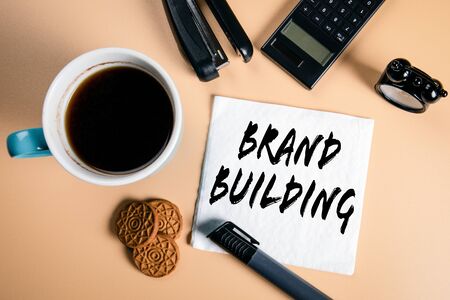 Brand building. Business, marketing and management concept. Text on a napkin with a cup of coffeeの写真素材