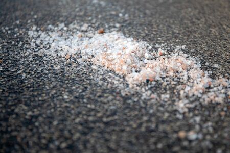 Salt spilled on the pavement. Winter season, slick and dangerous. Nature protection and ecologyの写真素材