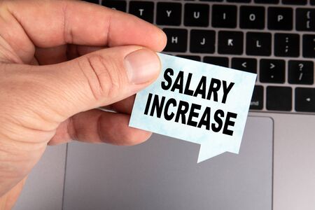 Salary Increase. Development, career, bonuses and planning concept. Speech bubble and laptop in the backgroundの写真素材