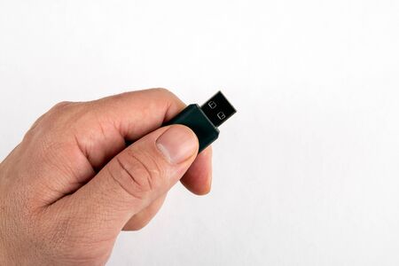 USB memory stick in male hand on white background with copy space. Data, information, security and technologyの写真素材