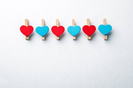 Wooden clips with red and blue heart. White background with copy space. Office Suppliesの写真素材