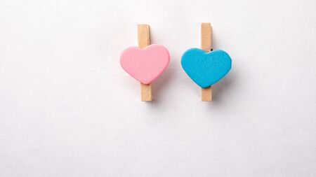 Wooden clips with Red, Pink and Blue heart. White background with copy space
