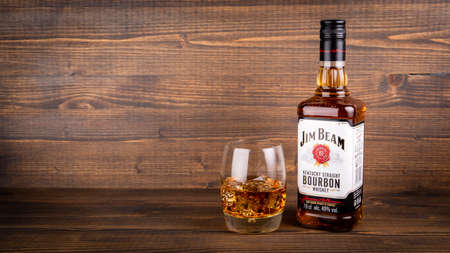 Bottle of Jim Beam Bourbon and a glass with ice on wooden backgroundのeditorial素材