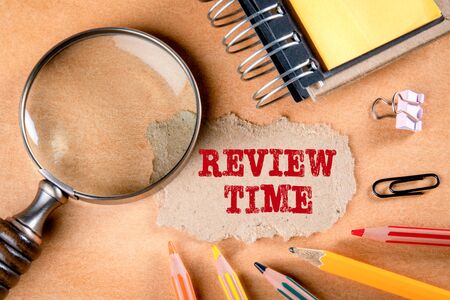 REVIEW TIME concept. Magnifying glass, stationery and note paperの写真素材
