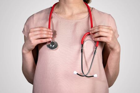 Female Doctor with a red stethoscope. Healthcare, assistance and emergencies conceptの写真素材