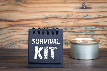 SURVIVAL KIT. Black notebook and can on a wooden backgroundの写真素材