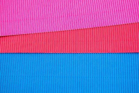 Corrugated application paper background. Pink, red and blue color. Place for textの写真素材