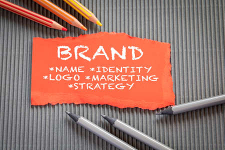 BRAND. Name, Identity, Logo and Marketing, Strategy concept. Text on torn, colored paperの写真素材
