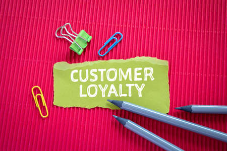 CUSTOMER LOYALTY concept. Text on torn, gren paperの写真素材