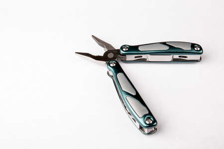 Multitool with pliers on white background. Top view. Tools for cutting, sawing, screwing,...