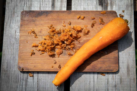 Peeled carrot on wooden stave. Preparation for cooking vegetablesの写真素材