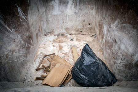 Wooden debris and black garbage bag in in waste containerの写真素材