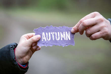 AUTUMN. Mother and child holding a note sheetの写真素材