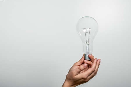 Light bulb in a womans hands. Free space for text and copy spaceの写真素材