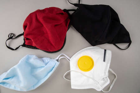 Different color face masks on a gray background. Virus spread, regulations and public safety conceptの写真素材