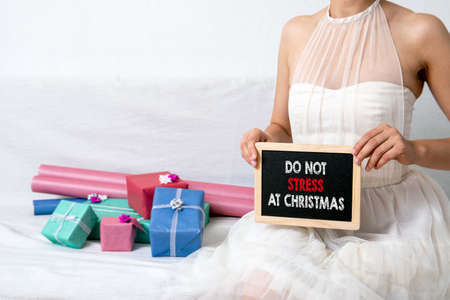 DO NOT STRESS AT CHRISTMAS. Women in ball dress. Gift boxes in colorful wrapping papeの写真素材