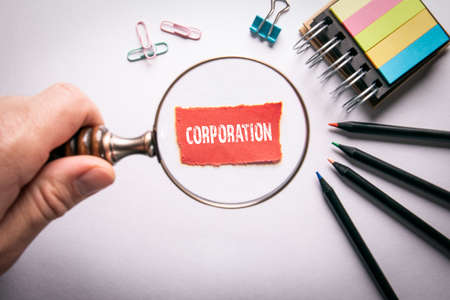 CORPORATION. Magnifying glass in a mans handの写真素材