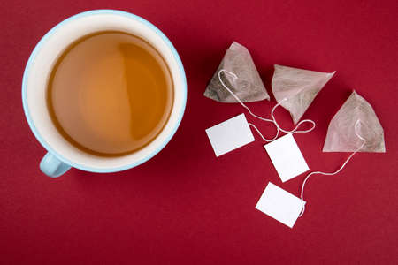 Teabags with label. Top view, on a red background. Mockupの写真素材