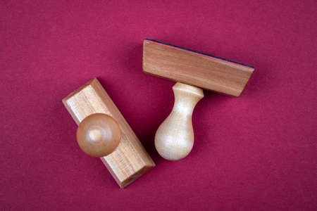 Wooden stamps on a red background. Business, regulation, rules and approval conceptの写真素材