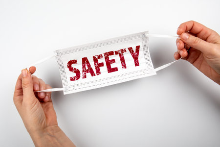 SAFETY, Covid-19 concept. Face mask in a womans handsの写真素材