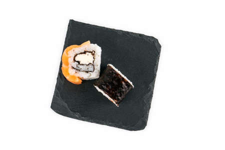 Sushi roll with salmon and stone surface on a white background. Food and japanese cultureの写真素材