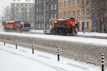 Snow cleaner car cleans snowy road and shedds salt. Snowstorm and heavy trafficのeditorial素材