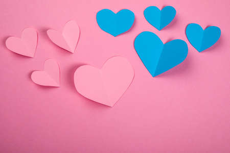 Pink and blue paper hearts on a pink background. Guys and girls, falling in love and passion conceptの写真素材